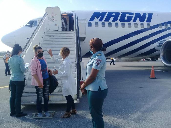 Migrante que le toman la temperatura al bajar del avión