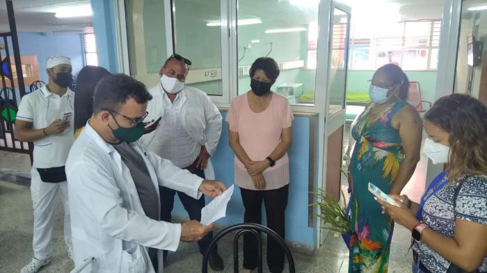Médicos dando el parte en el hospital, Ministra y Viceministra de Educación están presentes.
