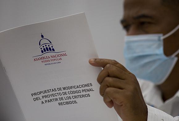 Diputado con folleto de propuestas de modificaciones del proyecto del código penal en la asamblea nacional del poder popular