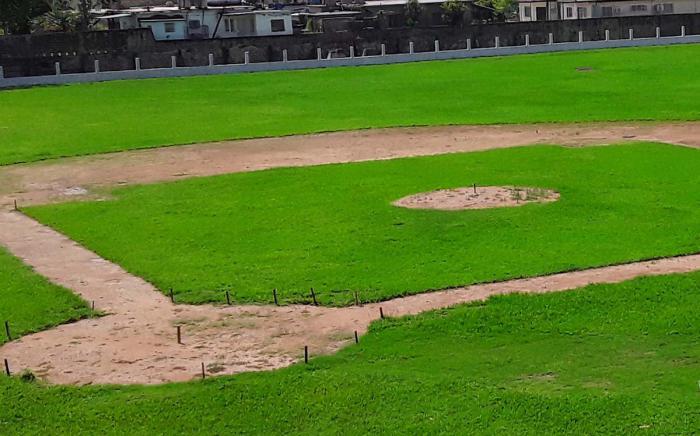 Se pueden observar las estacas puestas para el vertido de la arcilla en el terreno de pelota, y al fondo, la cerca intermedia, a la cual le quedaba pendiente ponerle los paños de la parte superior.