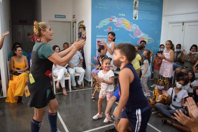 Una artista y niños en una actividad cultural