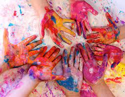 Manos de niños con pintura de diversos colores