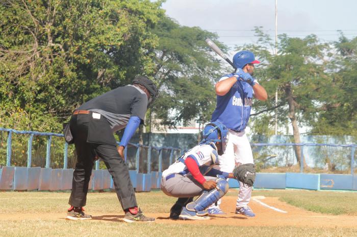 Tres personas en el terreno, uno batea