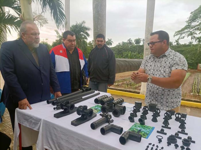 Juan Carlos Cabrera, al frente de la Mipyme JCMax, de La Lisa, explica al primer ministro Manuel Marrero Cruz las características de los sistemas de riego que producen en cooperación con la Unión de Industrias Militares.