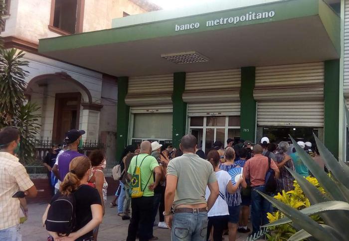 Personas en una cola afuera de un Banco Metropolitano