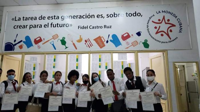 Miembros de Moneda Cubana con un diploma en las manos