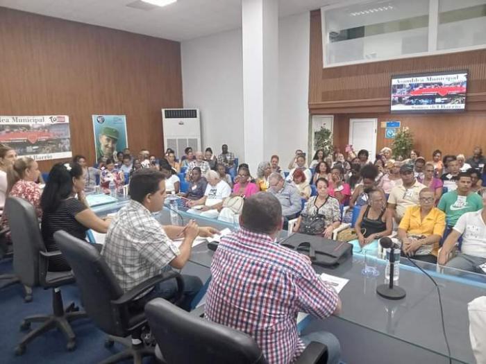Presidencia y participantes en la asamblea