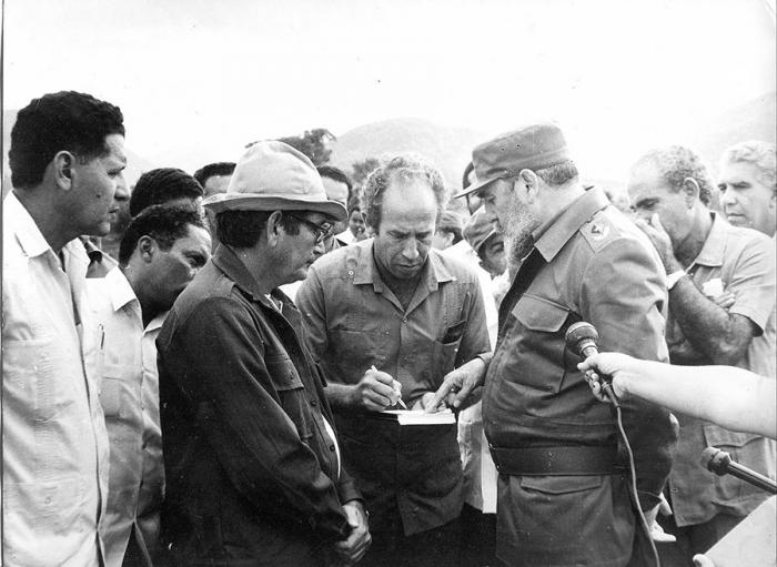 Nos estimulaba la constante presencia y preocupación del líder de la Revolución  por los trabajadores hidráulicos, afirma el ingeniero Ferrer, que aparece al centro, explicando datos técnicos de la presa Cauto El Paso en construcción.
