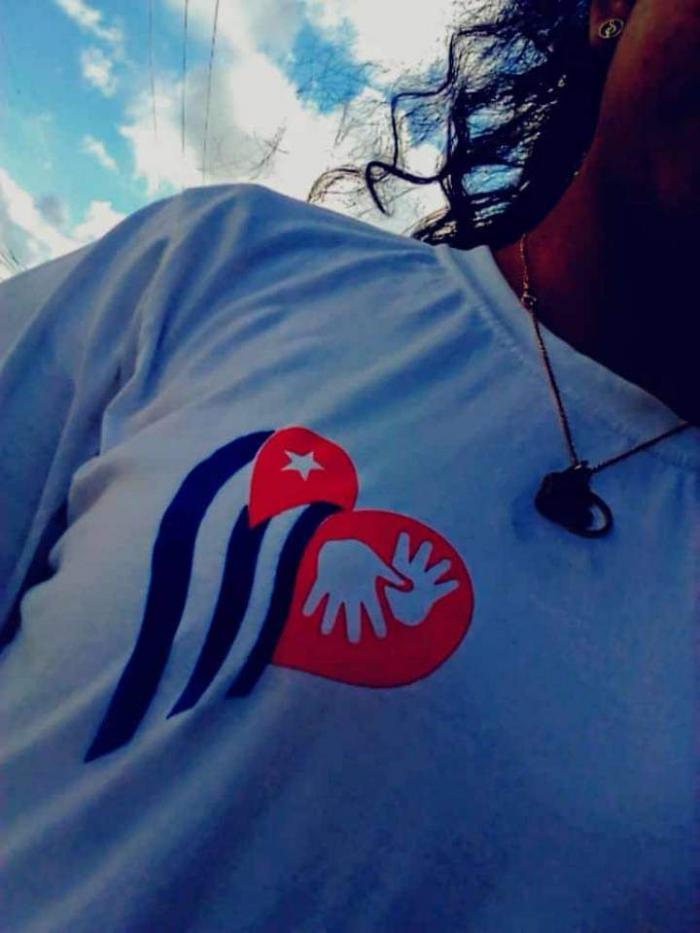 Muchacha con un pullover con el símbolo del lenguaje de señas y bandera cubana