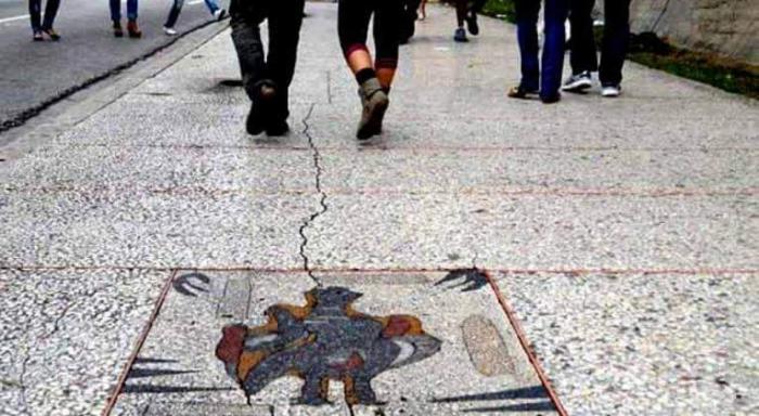 Personas que caminan por La Rampa, al frente un mosaico de la acera
