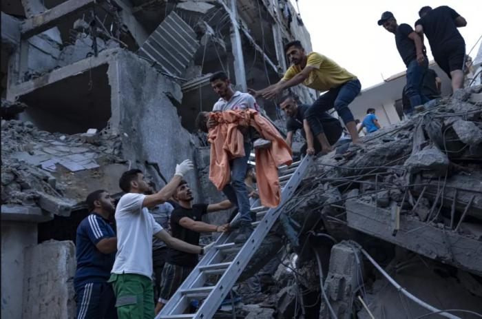 Palestinos rescatan a una niña de los escombros de un edificio residencial destruido luego de un ataque aéreo israelí, el martes 10 de octubre de 2023 