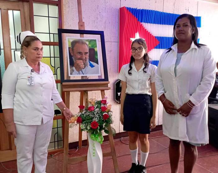 Personal de salud frente a una foto de Fidel