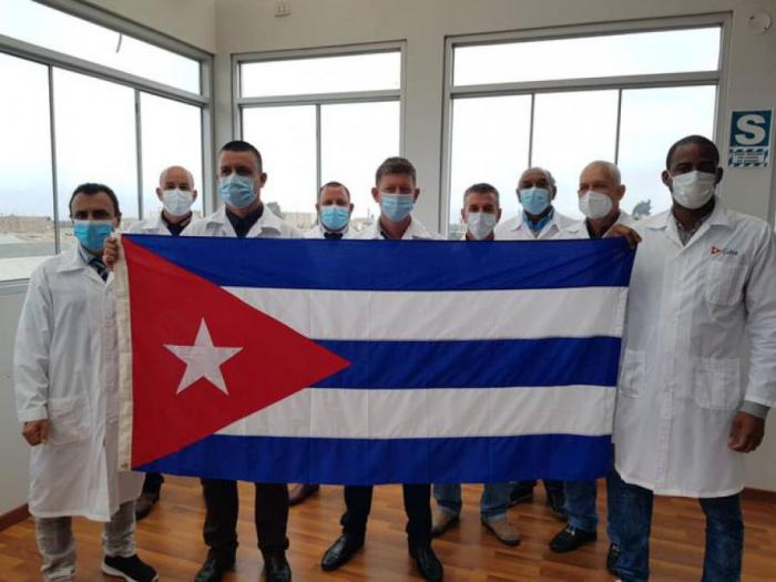Médicos cubanos con una bandera cubana