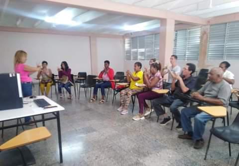 Personas en un aula aprendiendo el lenguaje de señas cubana para personas sordas