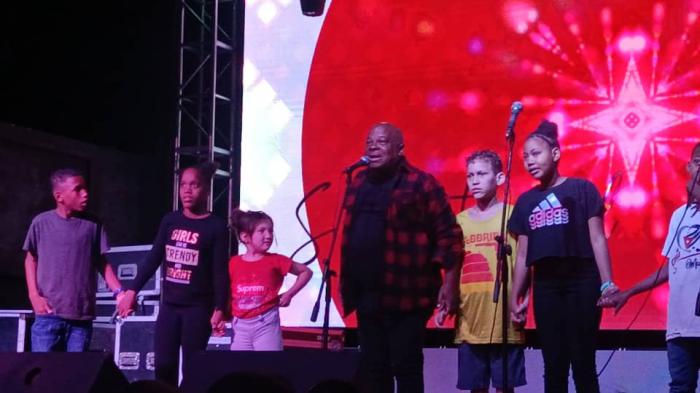 Waldo Mendoza junto a varios niños y adolescentes en el escenario