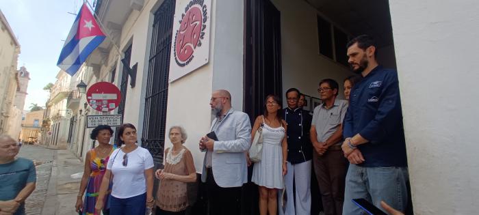 El curso se imparte en la sede de La moneda cubana, personas a la entrada de la sede