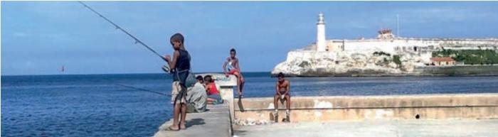 Niños pescando en el malecón habanero