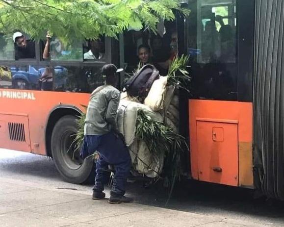 Ciudadano abordando el medio por la puerta trasera con una carretilla cargada de 11 sacos de pencas