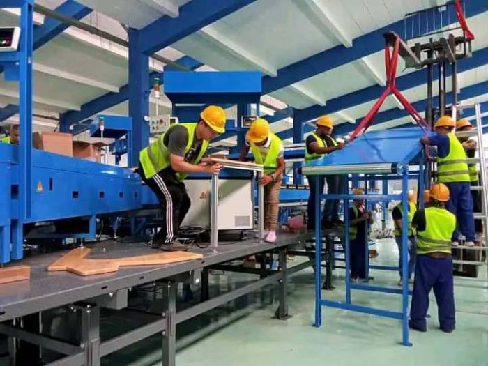 Jóvenes de la Empresa de Mensajería y Cambio Internacional laboran en el montaje de la nueva planta automatizada.