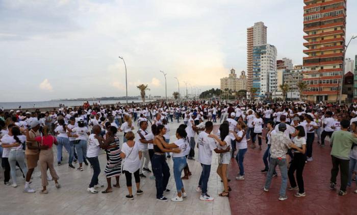 Personas bailando frente al Malecón habanero