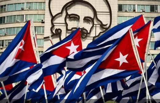 Banderas cubanas delante de la imagen de la escultura de Camilo en la Plaza de la Revolución.