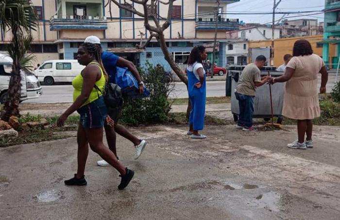 Personas limpiando calles de La Habana y recogiendo la basura.