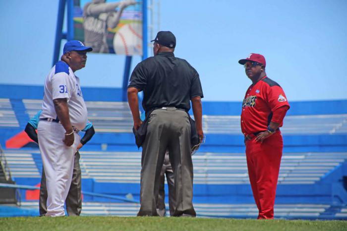 Carmona, director de Industriales junto a directivo de los Huracanes y árbitro de béisbol