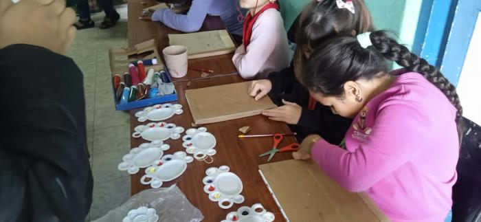 Niños encuadernando libros.