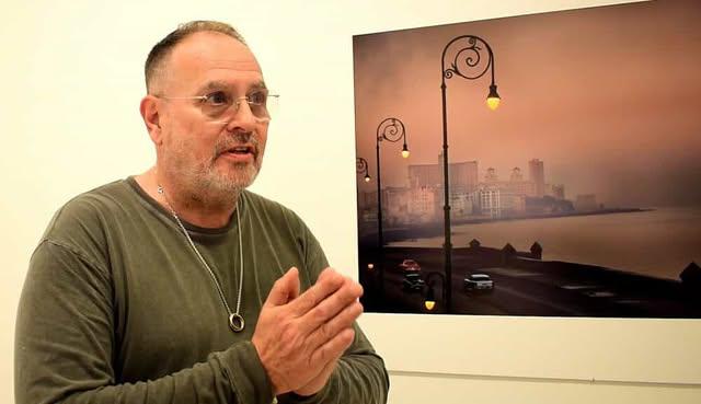 Versace estuvo presente en la inauguración. Al fondo una de sus obras sobre La Habana.