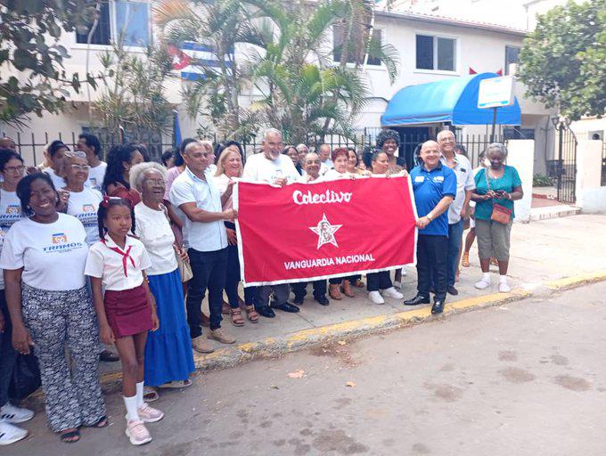 Trabajadores de Tramos con la bandera que los acredita como Vanguardias nacionales