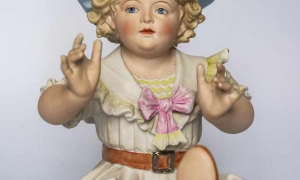 Bebé de piano Francia Siglo XX Porcelana, biscuit coloreado.