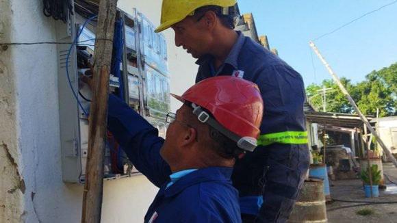 Dos trabajadores midiendo la electricidad