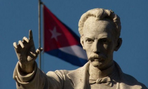 Escultura de José Martí y al fondo la bandera cubana