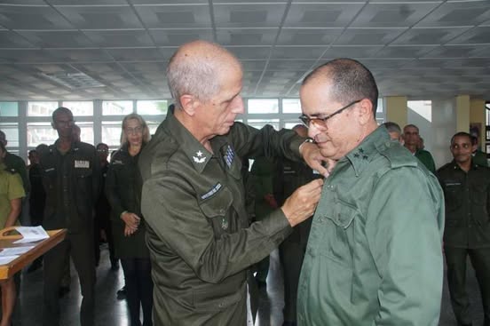 El General de Brigada Ramón Rodríguez Curbelo, jefe de la Dirección de Investigación Criminal del MININT, impuso la condición Elogio a la Virtud al coronel Alberto Ramón Palmero, jefe de la Dirección de Criminalística. Foto: MININT El General de Brigada Ramón Rodríguez Curbelo, jefe de la Dirección de Investigación Criminal del MININT, impuso la condición Elogio a la Virtud al coronel Alberto Ramón Palmero, jefe de la Dirección de Criminalística. Foto: MININT